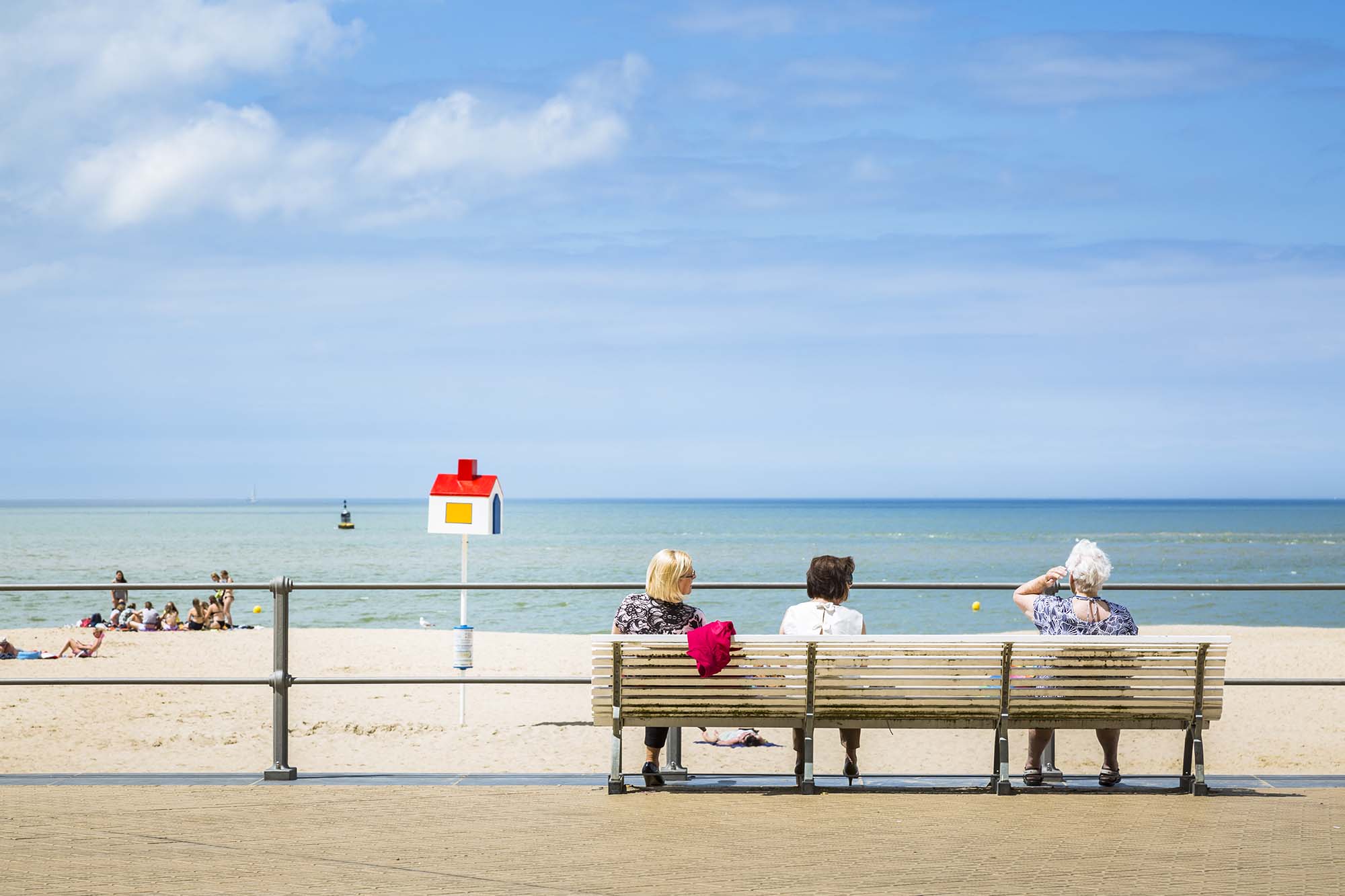 Three women on a bench at the beach